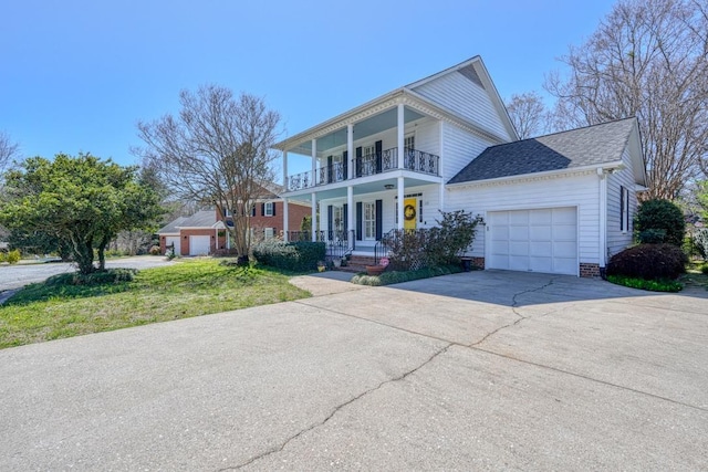 greek revival house with driveway, covered porch, roof with shingles, a garage, and a balcony
