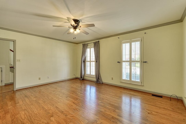 spare room featuring ceiling fan, visible vents, wood finished floors, and ornamental molding
