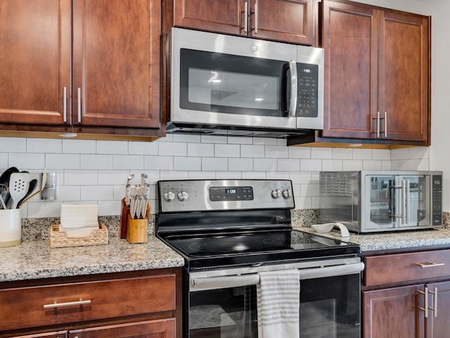 kitchen with light stone counters, tasteful backsplash, and stainless steel appliances