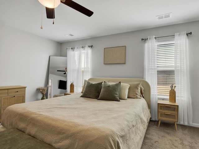 carpeted bedroom featuring visible vents and a ceiling fan