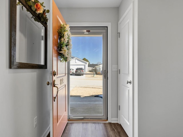 entryway with dark wood-type flooring and baseboards