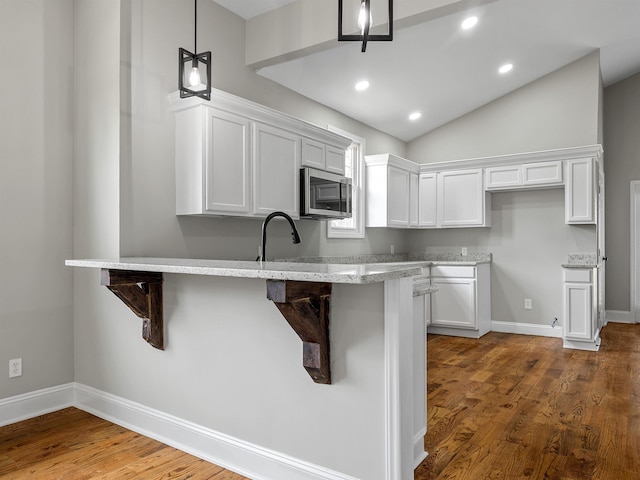802 Linley, Anderson, SC 29625 - kitchen with white cabinetry, light stone countertops, a kitchen breakfast bar, and stainless steel microwave