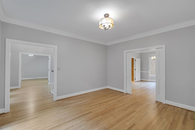 unfurnished room featuring baseboards, a notable chandelier, crown molding, and light wood-style flooring