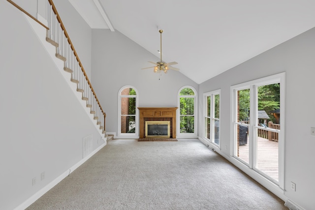 unfurnished living room featuring high vaulted ceiling, carpet flooring, a ceiling fan, a fireplace, and visible vents