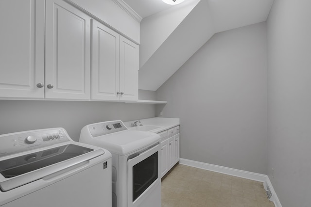 laundry area featuring baseboards, light floors, a sink, washer and dryer, and cabinet space