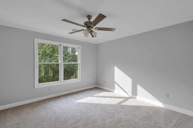 carpeted empty room featuring a ceiling fan, ornamental molding, and baseboards