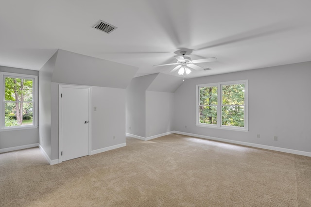 additional living space featuring a ceiling fan, baseboards, light colored carpet, and visible vents
