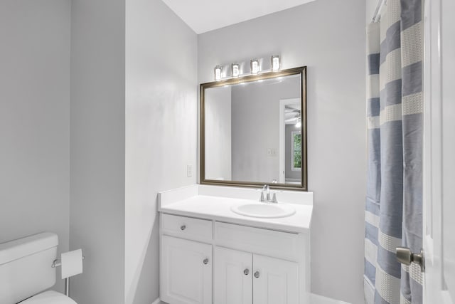 full bath featuring toilet, vanity, and a shower with shower curtain
