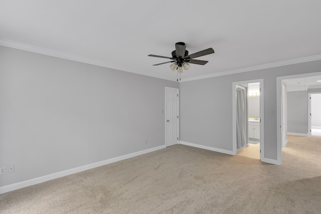 empty room featuring crown molding, baseboards, light colored carpet, and ceiling fan