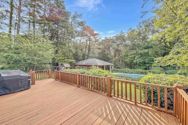 wooden deck featuring a grill and a swimming pool