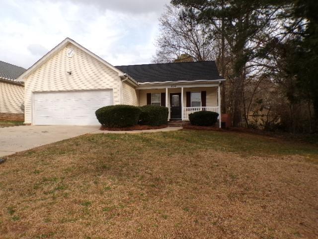 view of front of property with a front lawn, a porch, a garage, and concrete driveway