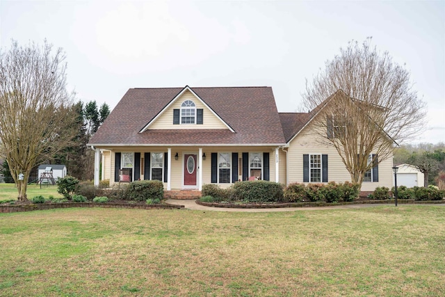 traditional home with a shingled roof, a front yard, covered porch, and a garage