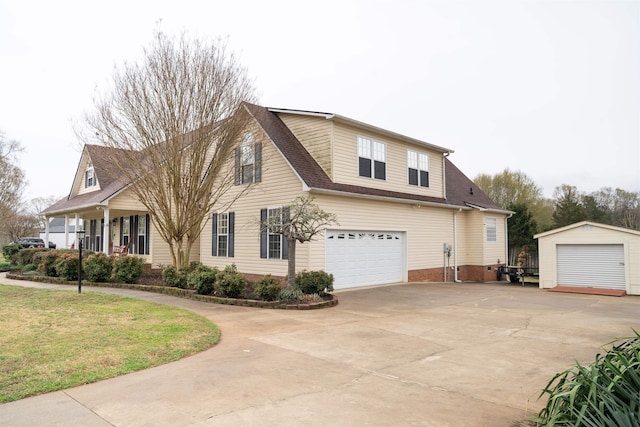 view of front of house with a front yard, concrete driveway, roof with shingles, an attached garage, and brick siding