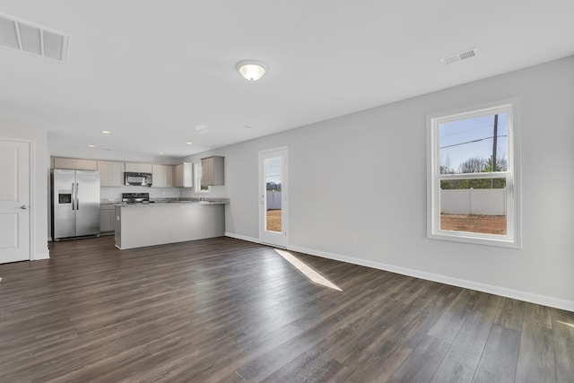 unfurnished living room with dark wood finished floors, recessed lighting, baseboards, and visible vents