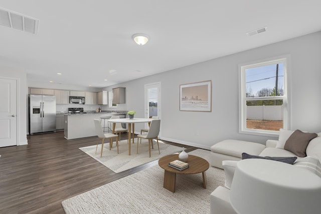 living room with dark wood finished floors, recessed lighting, baseboards, and visible vents