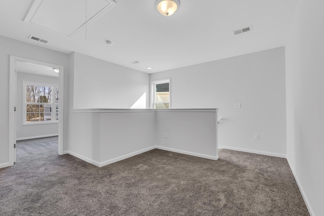 spare room with attic access, visible vents, and a healthy amount of sunlight