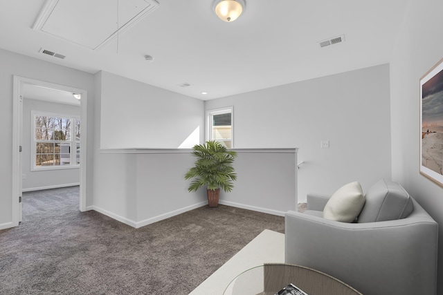 sitting room with carpet flooring, plenty of natural light, attic access, and visible vents