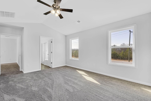 interior space with carpet flooring, baseboards, lofted ceiling, and visible vents
