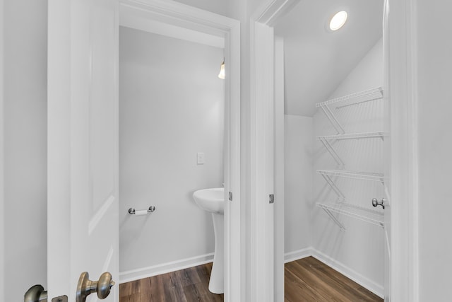 bathroom with baseboards, lofted ceiling, and wood finished floors