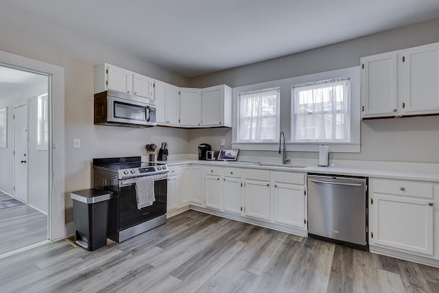 353 E Georgia, Woodruff, SC 29388 - kitchen featuring light countertops, a sink, white cabinetry, appliances with stainless steel finishes, and light wood-type flooring