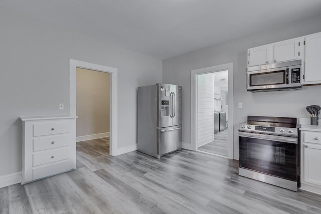 353 E Georgia, Woodruff, SC 29388 - kitchen with light countertops, appliances with stainless steel finishes, light wood-style flooring, baseboards, and white cabinets