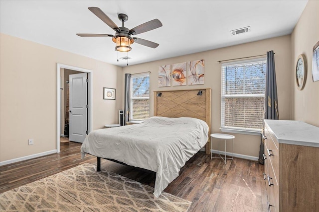 bedroom featuring baseboards, visible vents, and wood finished floors