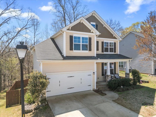 craftsman-style house featuring covered porch, fence, board and batten siding, and concrete driveway