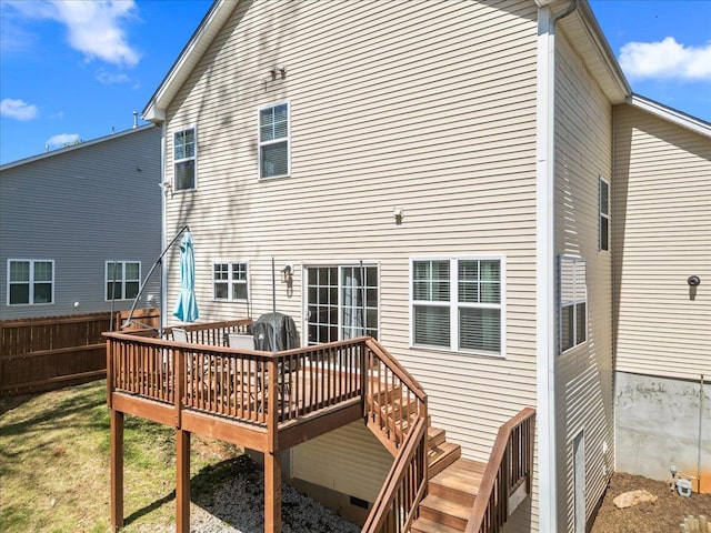 rear view of house featuring fence and a wooden deck