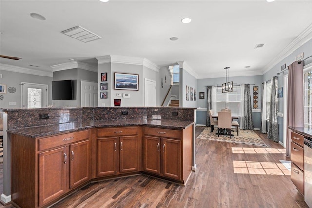 kitchen featuring visible vents, an inviting chandelier, brown cabinets, and dark wood finished floors