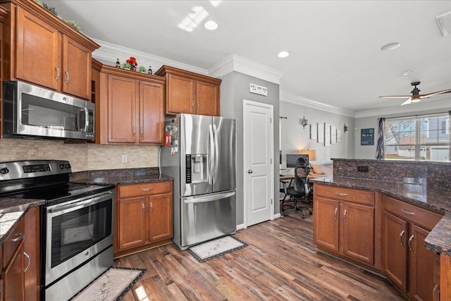 kitchen featuring appliances with stainless steel finishes, brown cabinetry, dark wood-type flooring, and decorative backsplash