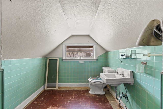 239 Phillips, Greenville, SC 29609 - half bathroom featuring tile walls, a textured ceiling, toilet, a sink, and vaulted ceiling