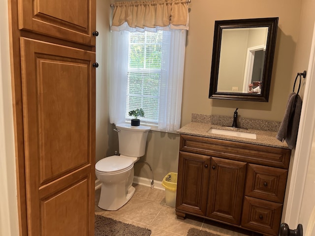 bathroom with tile patterned floors, toilet, baseboards, and vanity