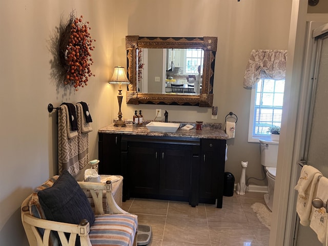 bathroom with baseboards, toilet, and vanity