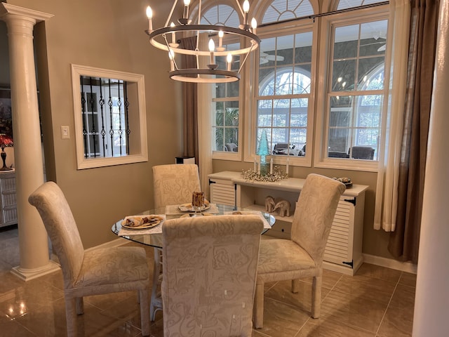 dining room with decorative columns, tile patterned flooring, a notable chandelier, and baseboards