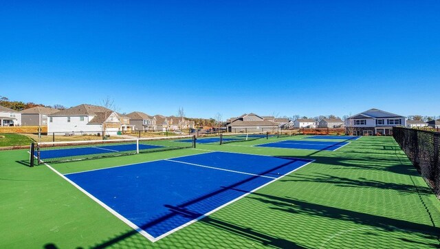 view of sport court featuring fence and a residential view