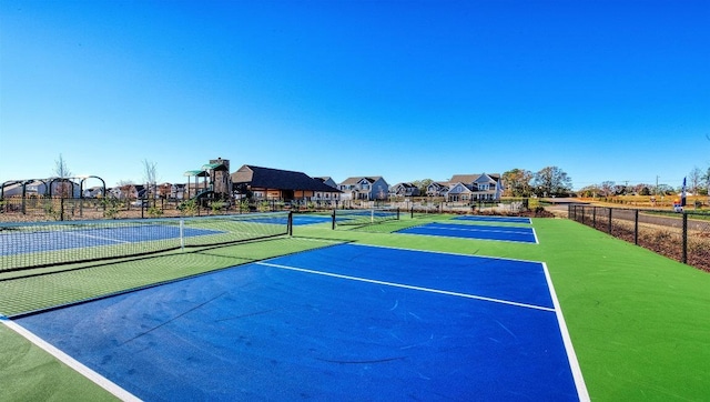 view of sport court with a tennis court and fence