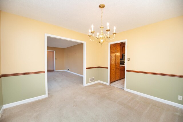 unfurnished room featuring light carpet, baseboards, a notable chandelier, and visible vents