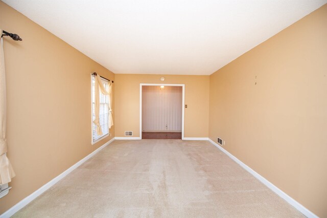 spare room featuring light carpet, baseboards, and visible vents
