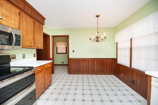 kitchen featuring light countertops, visible vents, wainscoting, appliances with stainless steel finishes, and a notable chandelier