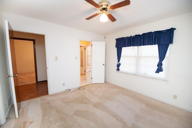 unfurnished bedroom with a ceiling fan, carpet, and baseboards