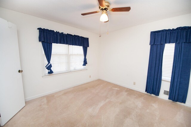 unfurnished room with baseboards, ceiling fan, and carpet