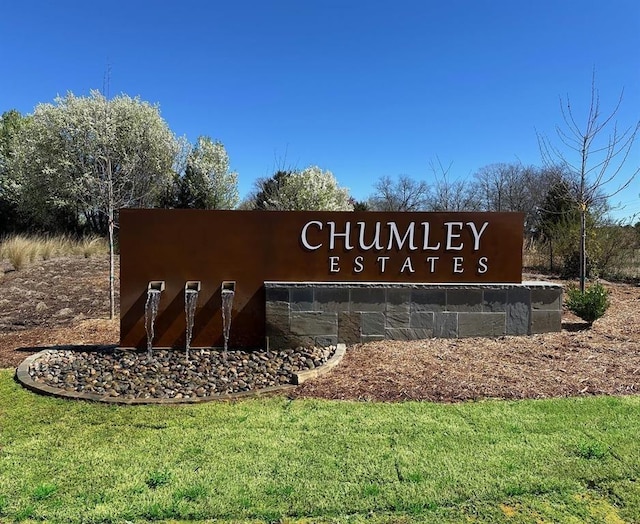 community sign featuring a yard