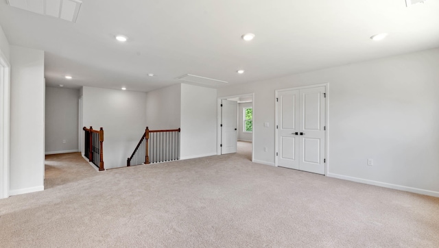 carpeted spare room with attic access, baseboards, and recessed lighting