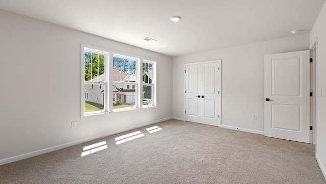 unfurnished bedroom featuring carpet floors, baseboards, and a closet
