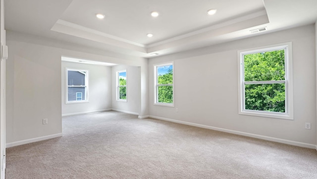 unfurnished room featuring a raised ceiling, ornamental molding, carpet, baseboards, and recessed lighting