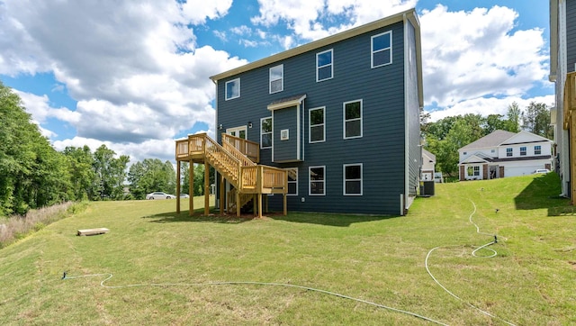 rear view of house featuring stairway, a wooden deck, a lawn, and central AC