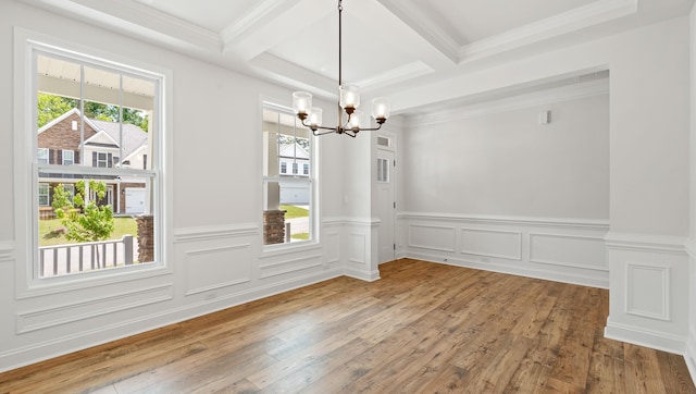 unfurnished dining area with a chandelier, beamed ceiling, a wainscoted wall, hardwood / wood-style flooring, and coffered ceiling