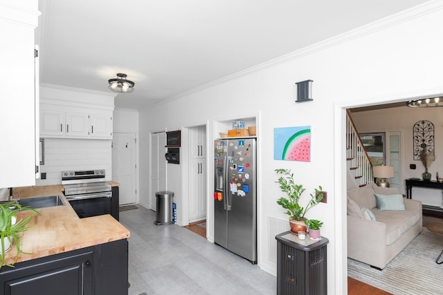 kitchen featuring white cabinetry, crown molding, a sink, visible vents, and appliances with stainless steel finishes
