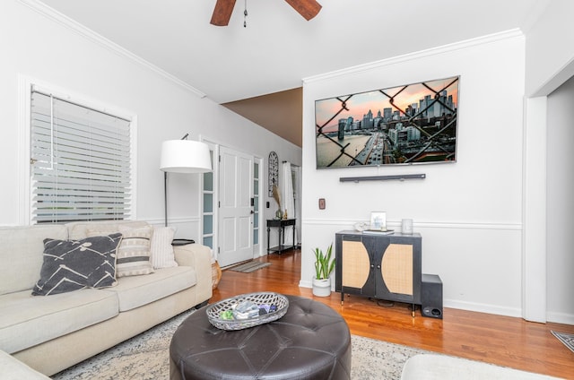 living area featuring baseboards, wood finished floors, ceiling fan, and ornamental molding