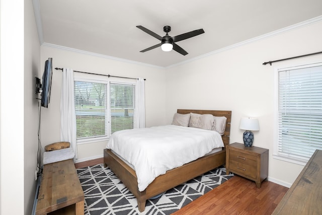 bedroom featuring crown molding, baseboards, and wood finished floors